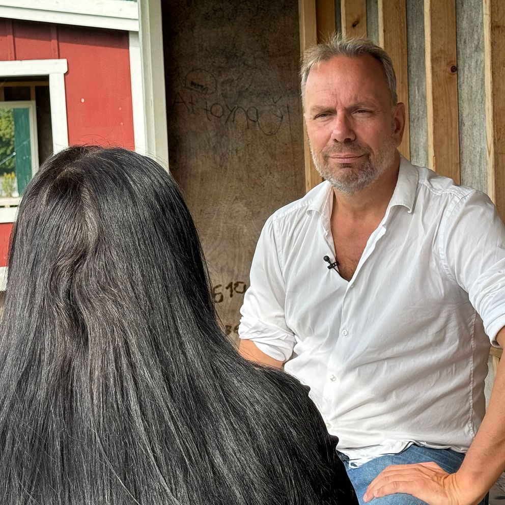 anonym kvinna bakifrån och man i skjorta som sitter framför henne