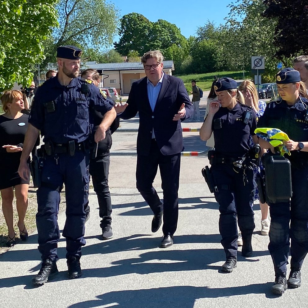 Justitieminister och poliser som går.