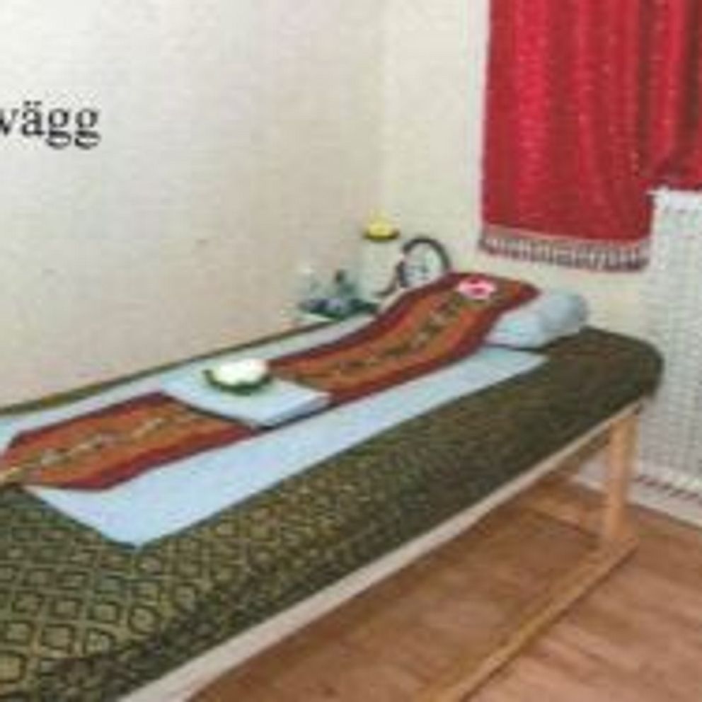 Enkel bädd i enkelt inrett rum med röd gardin och texten ”Inre vägg” på väggen.