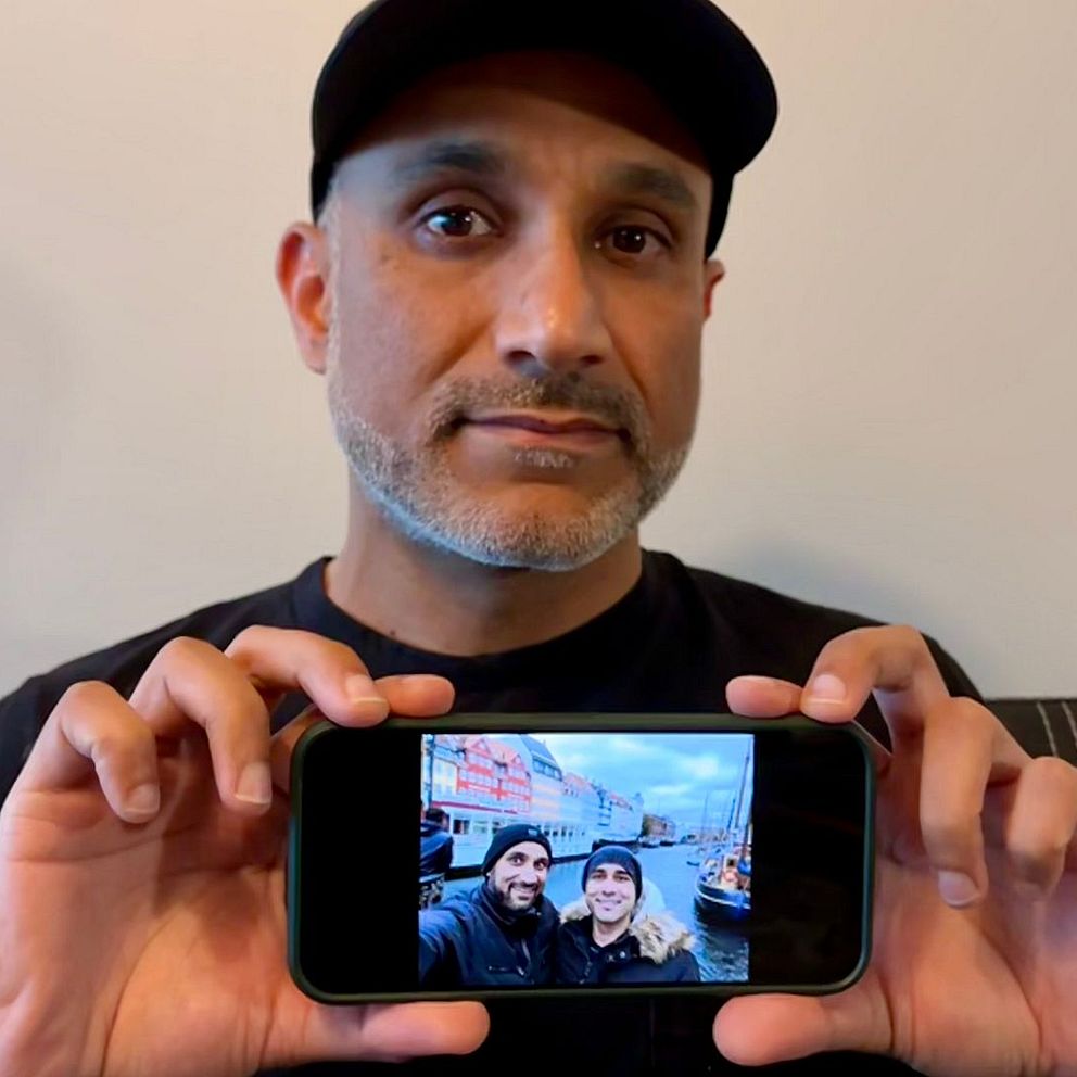 Qasim håller upp en mobil med en bild på hans bror som dog