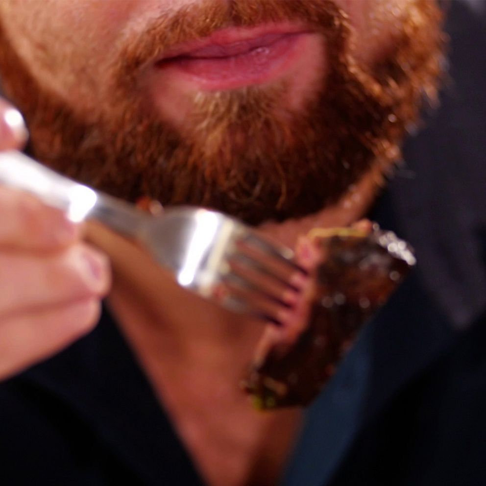 Man med kött på gaffel