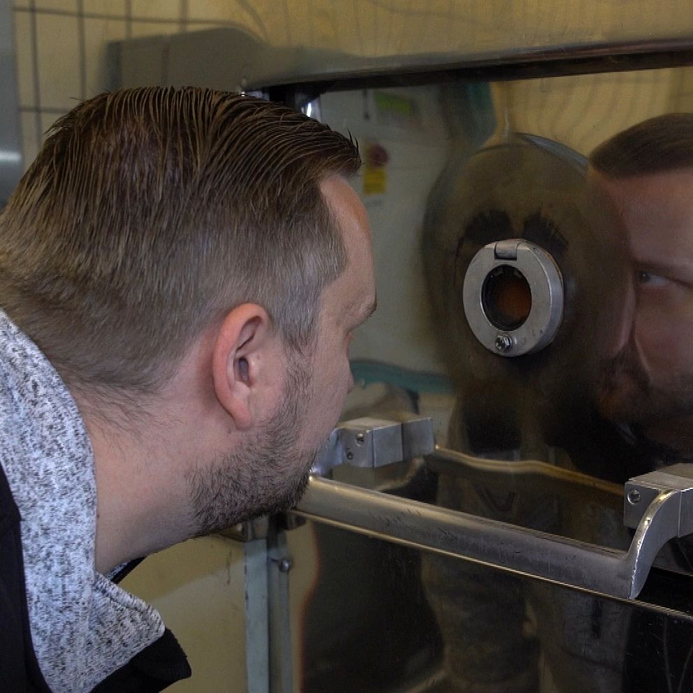 Man tittar in genom titthål i kremeringsugn