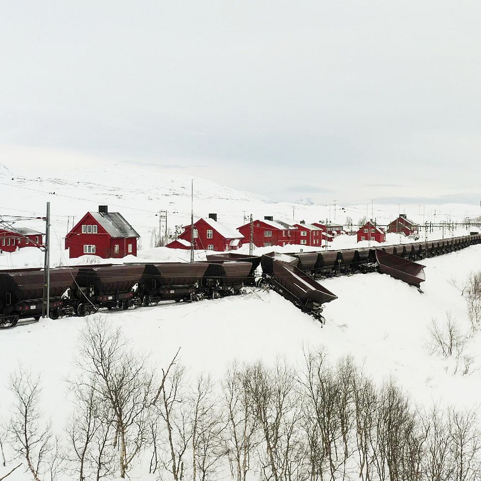 Bild på ett malmtåg och en vagn som spårat ur.