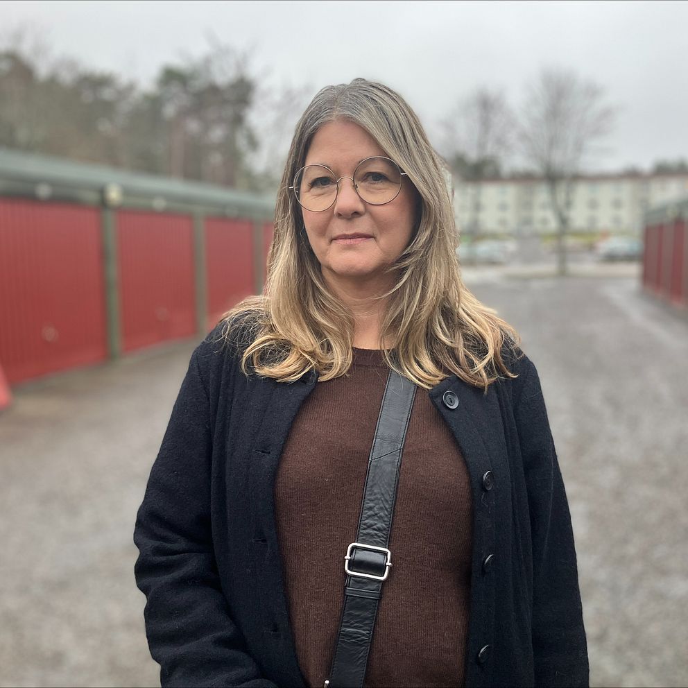 En kvinna som står vid garagelängor.