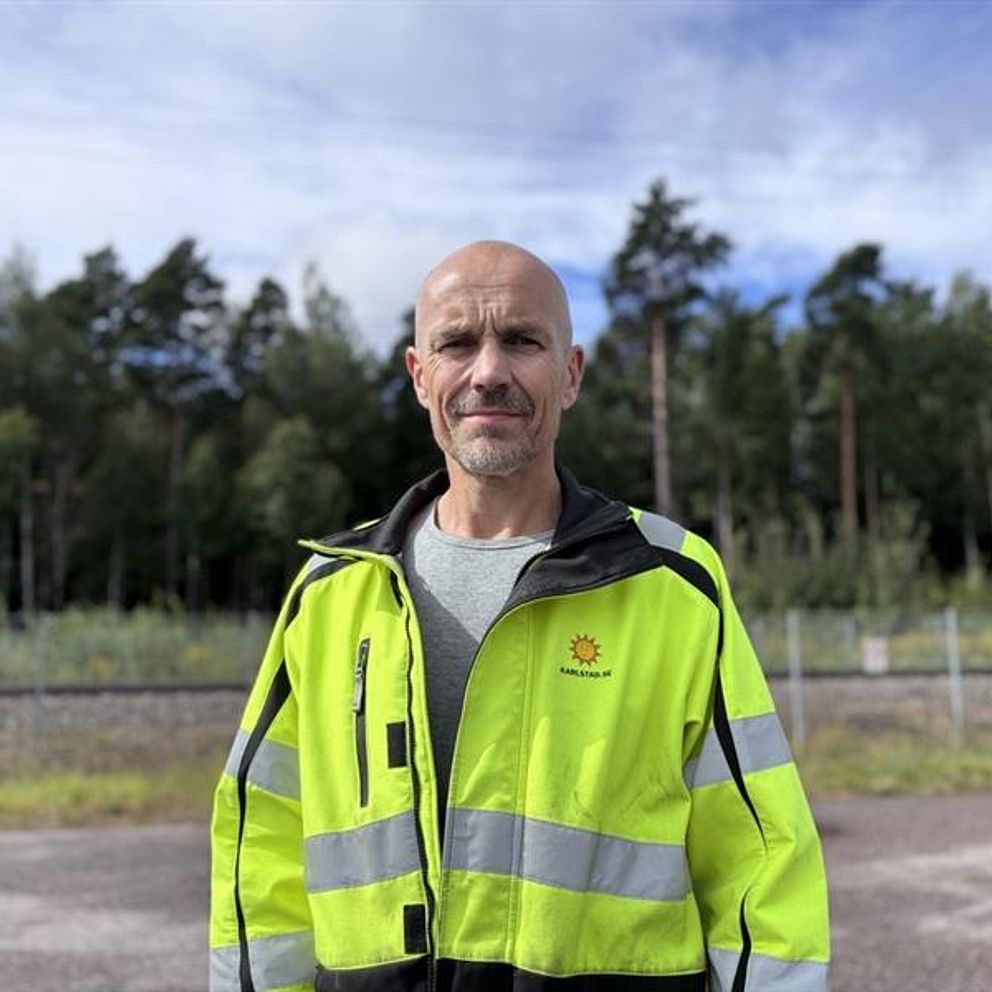 Pär Ungberg i gul varseljacka utomhus vid skog och väg i Karlstad.