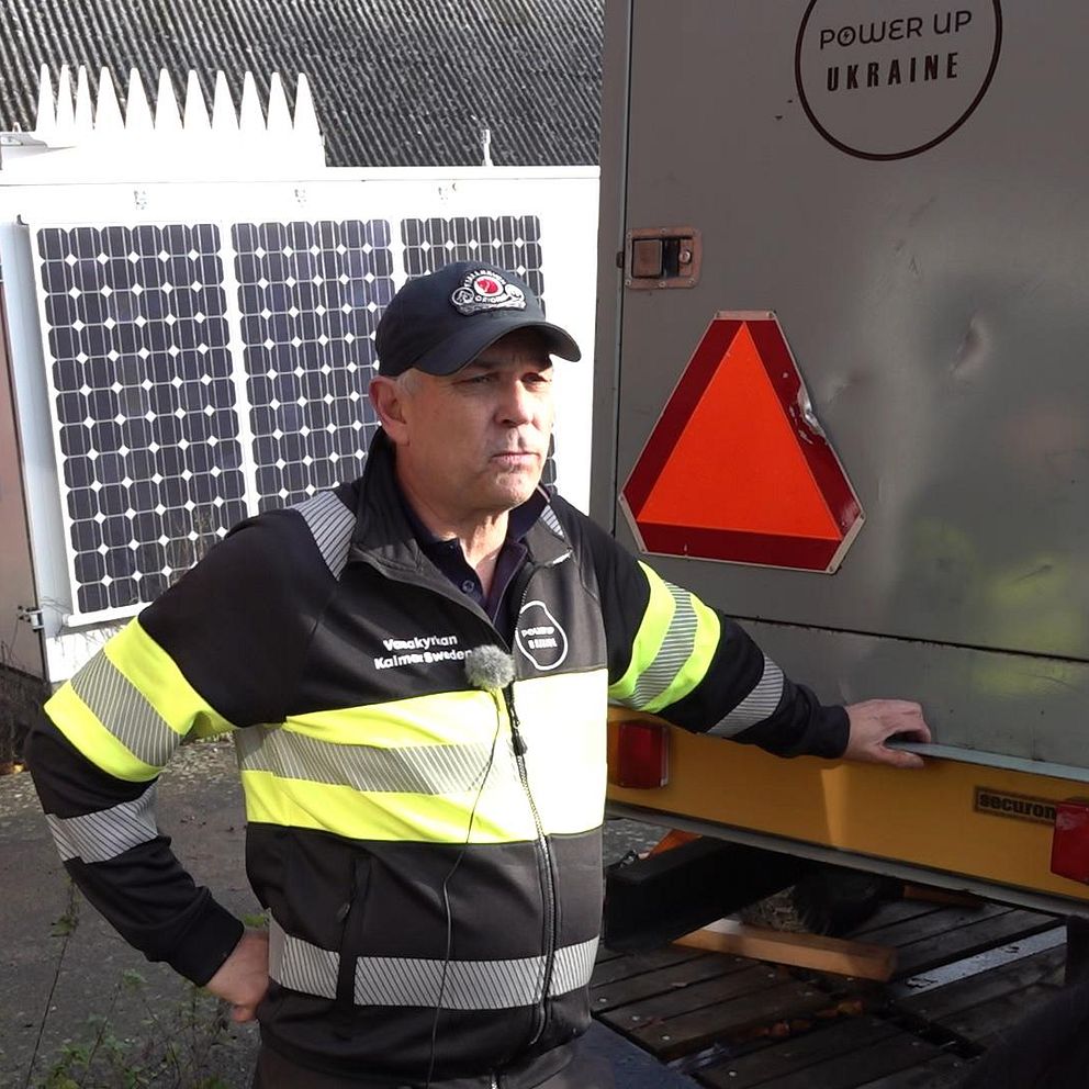 En man står vid en lastbil och lutar sig, på lastbilen står Power up Ukraine