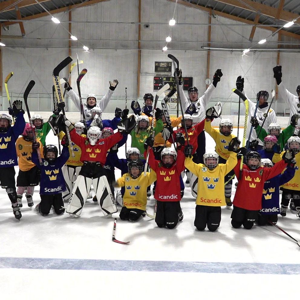 Hockeyspelande flickor sträcker klubborna i luften