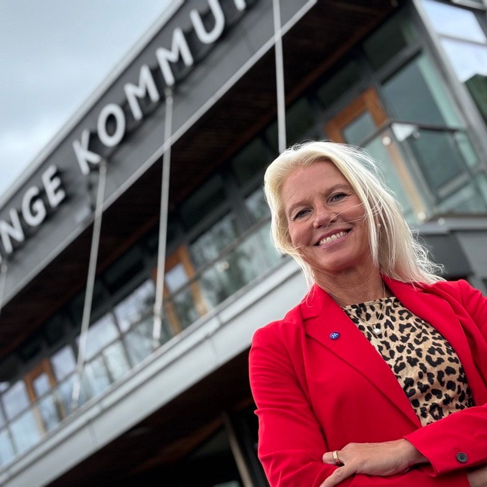 Carina Wutzler i röd kavaj framför Vellinges kommunhus
