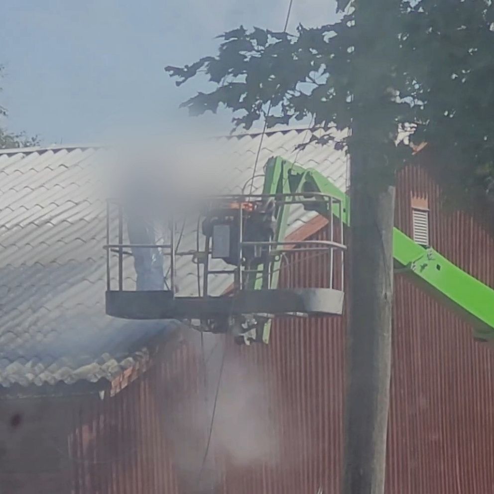 Arbetare i skylift tvättar ett tak på ridhuset i Alvesta. En tjock dimma från vattnet syns i luften.