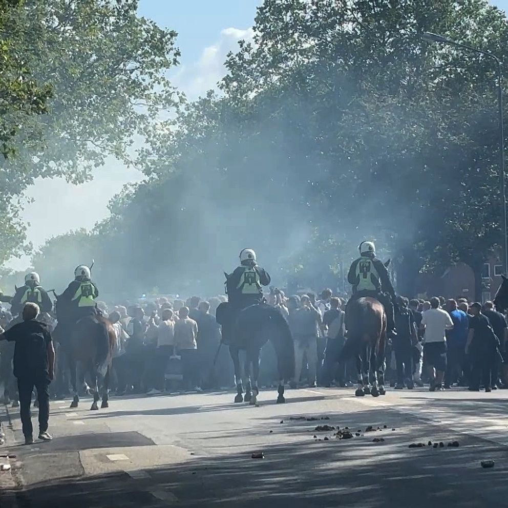 Polis på hästar skingrar FCK- och MFF-supportrar vid Lorensborgstorget efter bengalkastning.