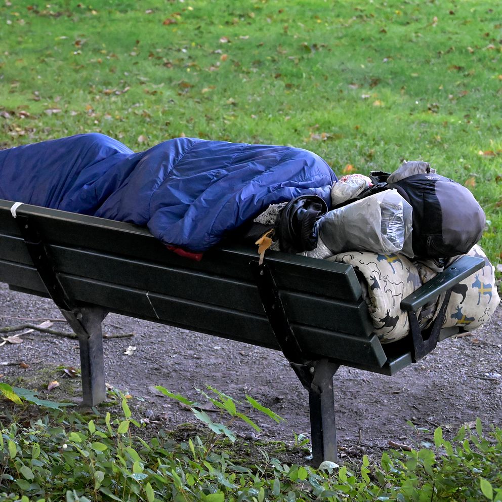 hemlös sover på bänk