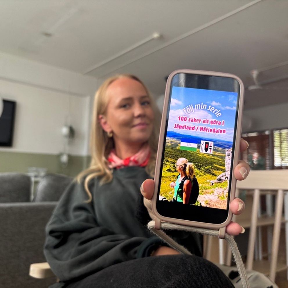 Josefin Blom visar upp sin mobil där vinjetten till hennes serie syns.