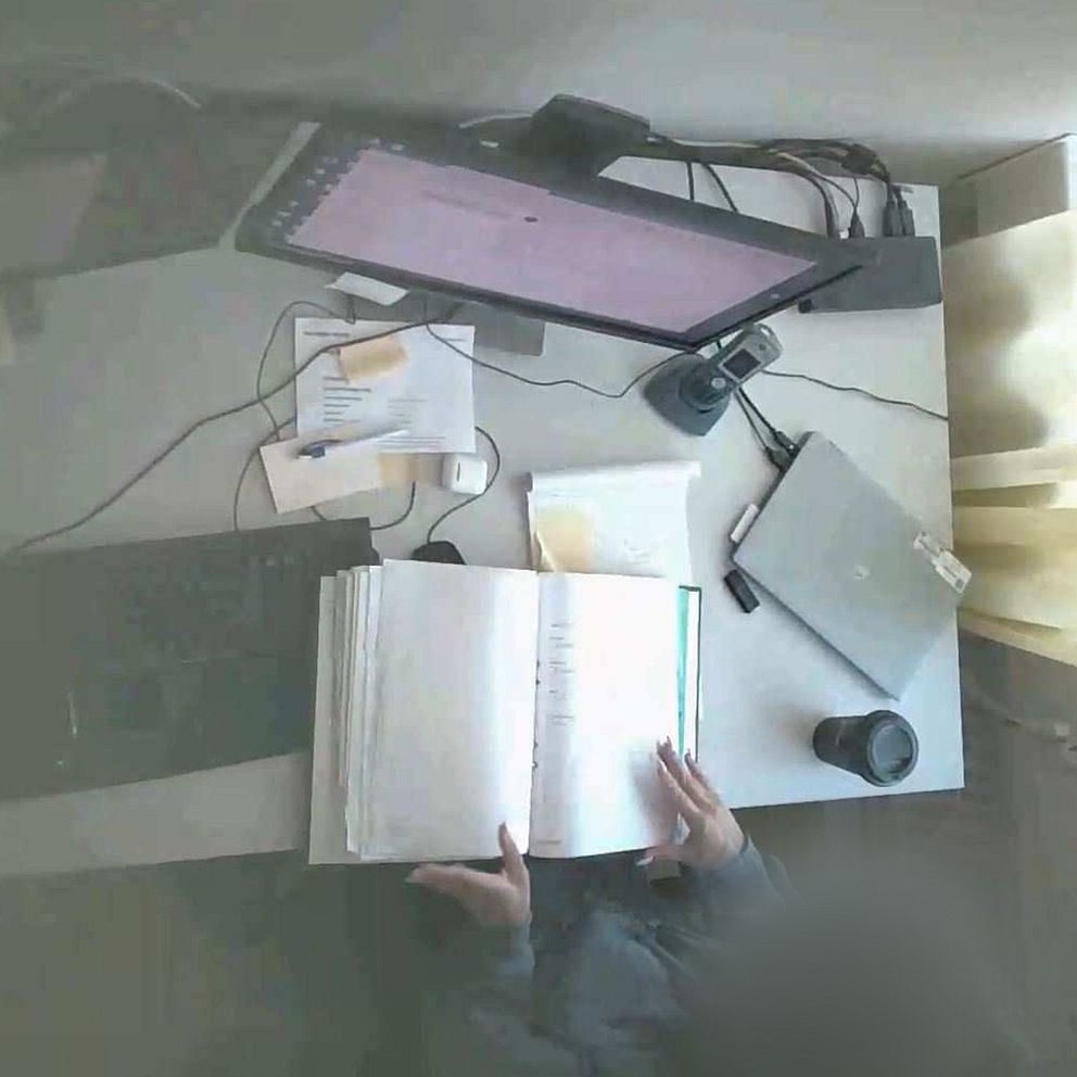 Den åtalade kvinnan sitter vid ett skrivbord.