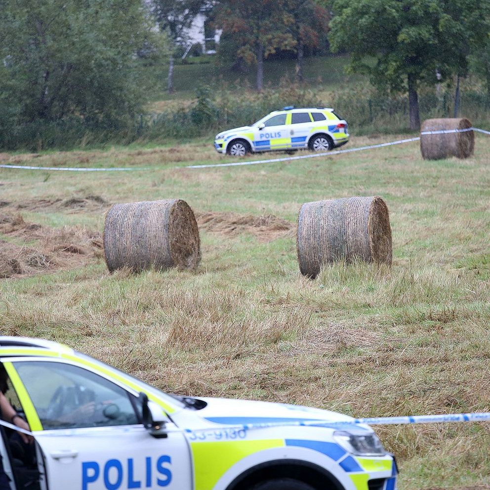 Polisbilar vid en åker.
