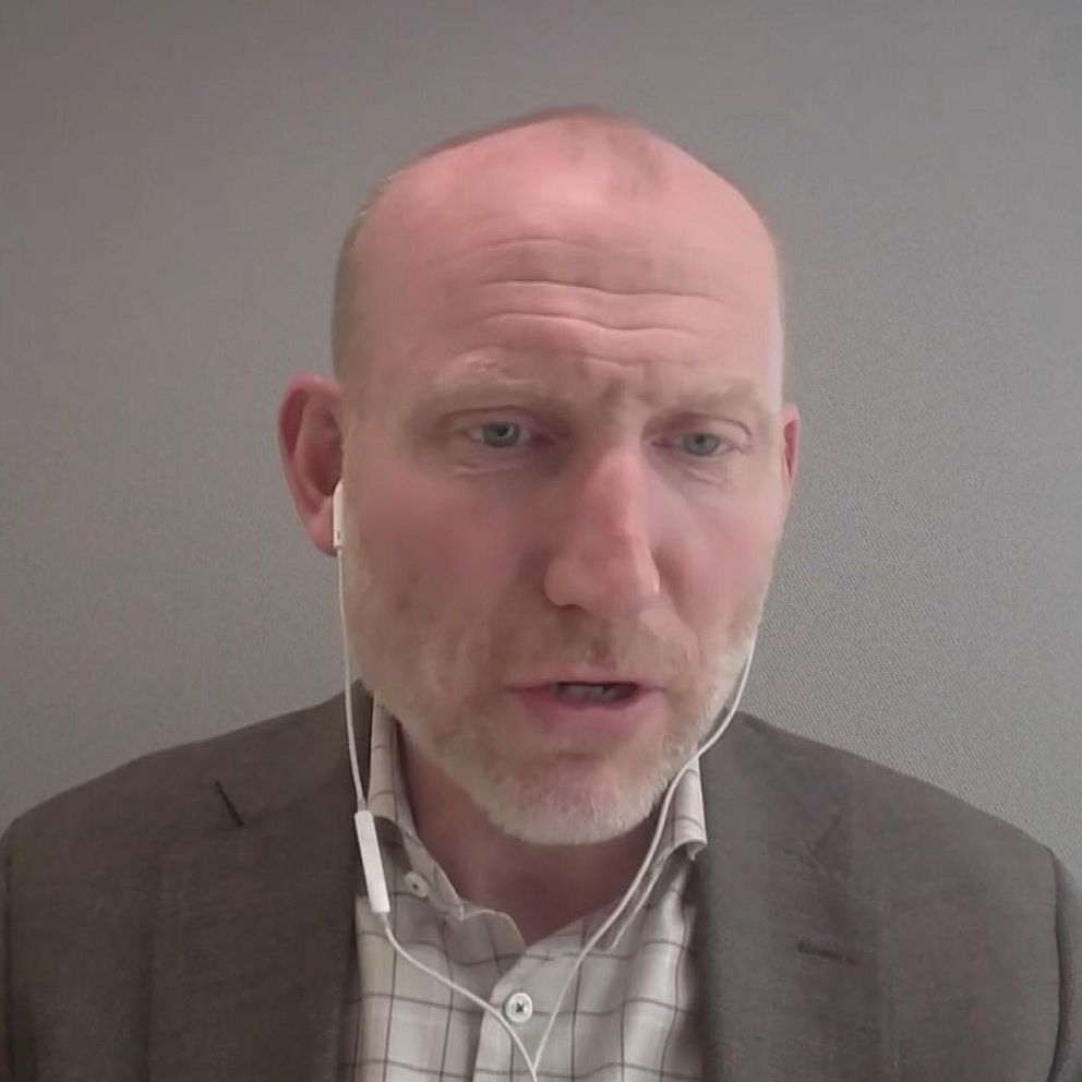 Man i kostym sitter i ett kontorsrum under en videointervju.
