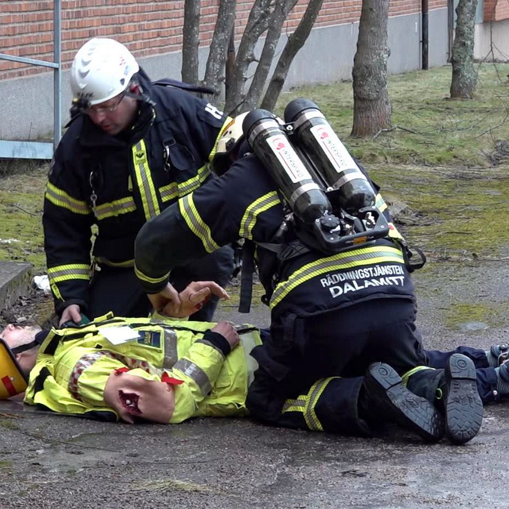 Två brandmän, kollar puls på ”skadad” kollega.