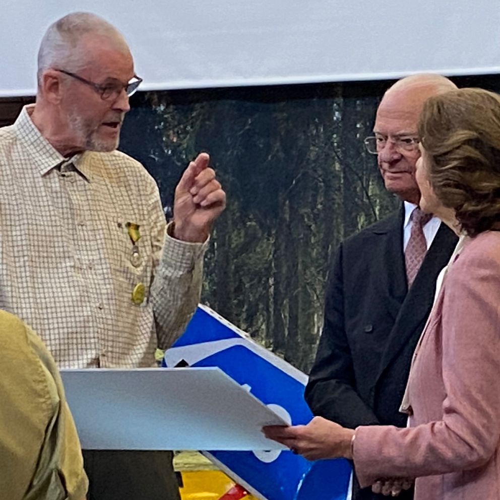 Skogsägaren Mats Helge berättar och visar en bild för kungaparet på vad han har planterat för träd efter stormen Gudrun.