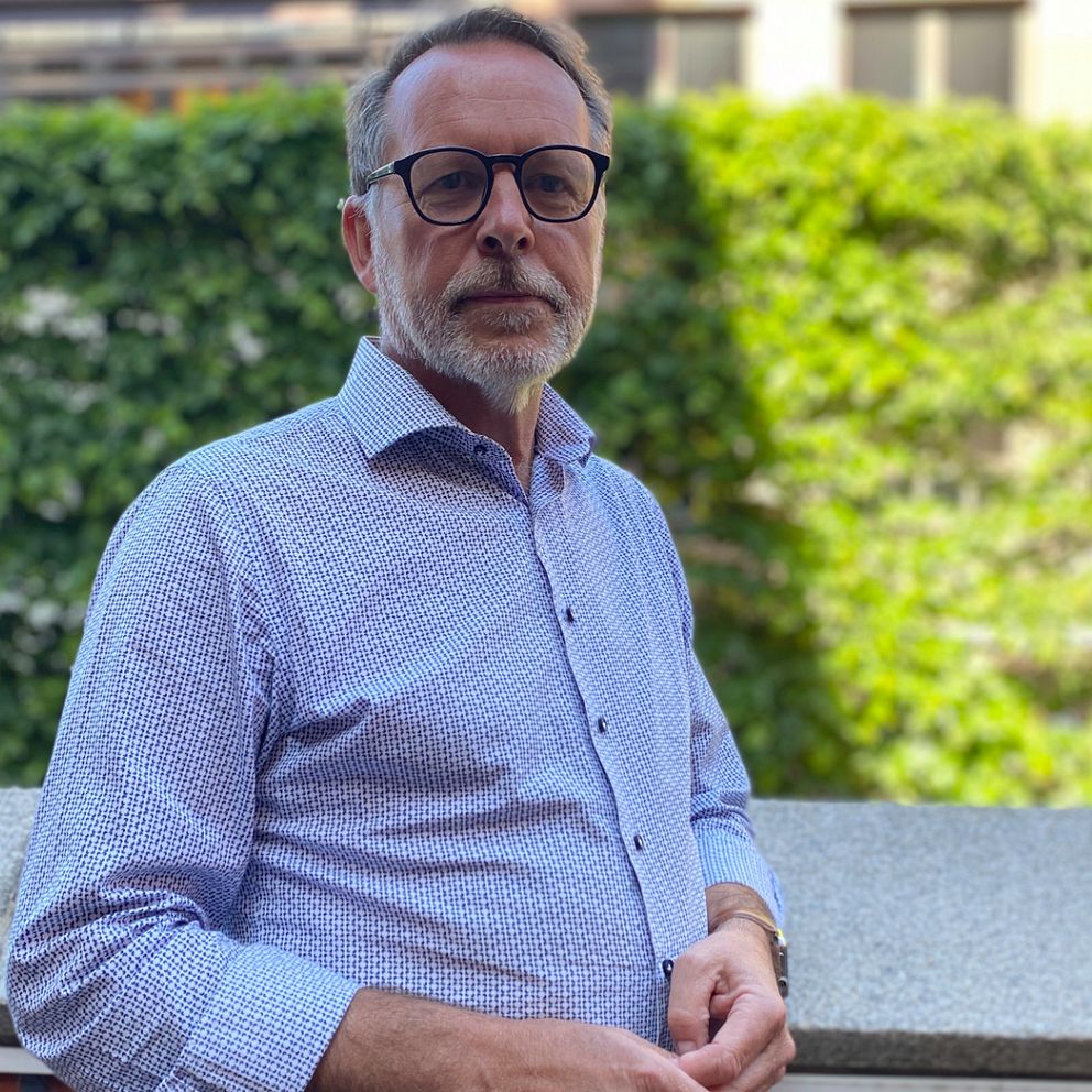 Lars Thunberg (KD) är ordförande för vård- och omsorgsnämnden i Helsingborg. Han står på Rådhusterrassen framför en allé av träd i bakgrunden.