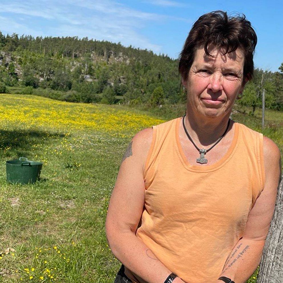 Hästägaren Kristina Borg, kvinna i linne lutar sig mot ett träd.