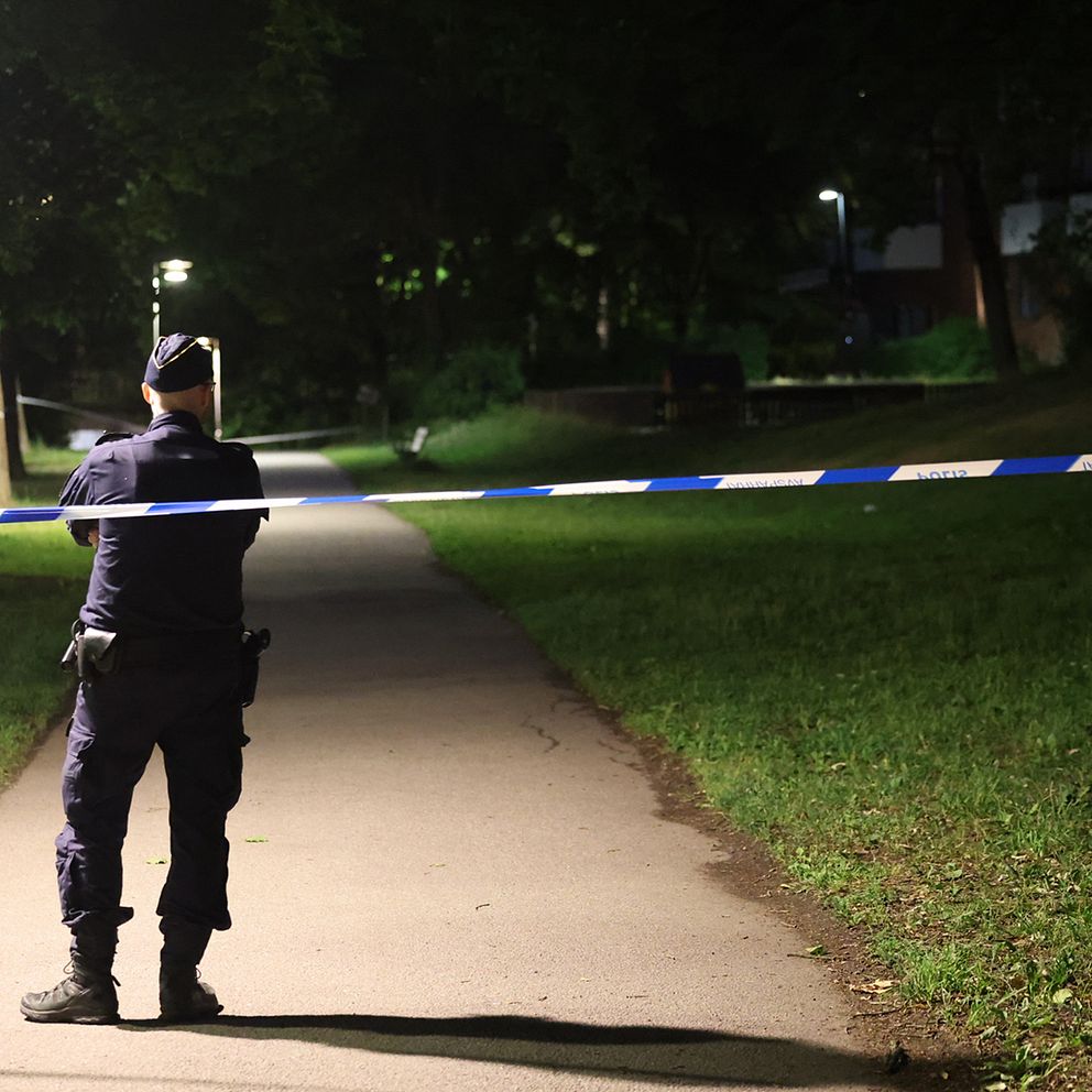 Polis står bakom ett avspärrningsband i Farsta.