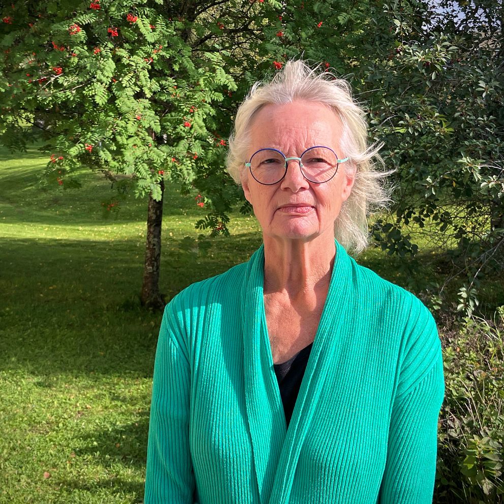 Åse Schoultz, åklagare står med grön tröja och runda glasögon.