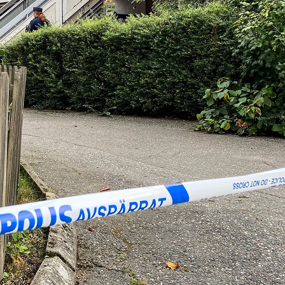 En polisavspärrning som går över en asfalterad väg.
