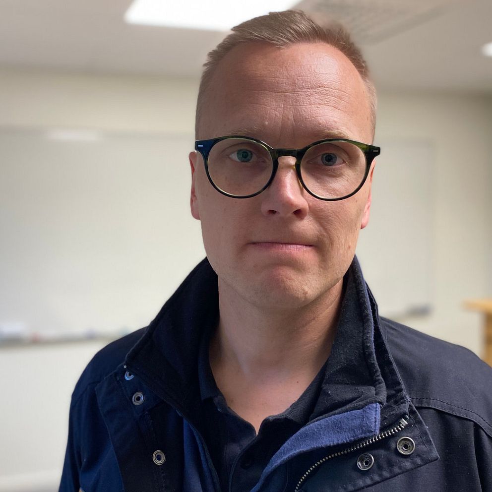Man med glasögon och blå jacka. Heter Henrik Starkman och är rektor