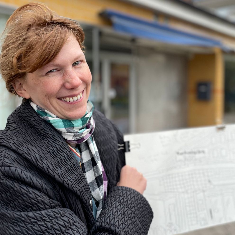 Serietecknaren Saskia Gullstrand står utanför en bowlinghall i Hässleholm med en skiss i handen.