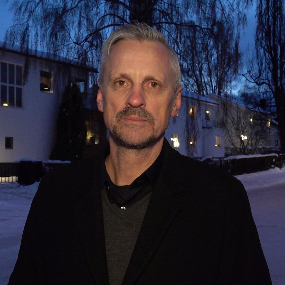 Bild på kommunpolisens Henrik Blusi utanför polisstationen i Sundsvall. I bakgrunden ser man att det är vinter och skymning och man ser ett hus.