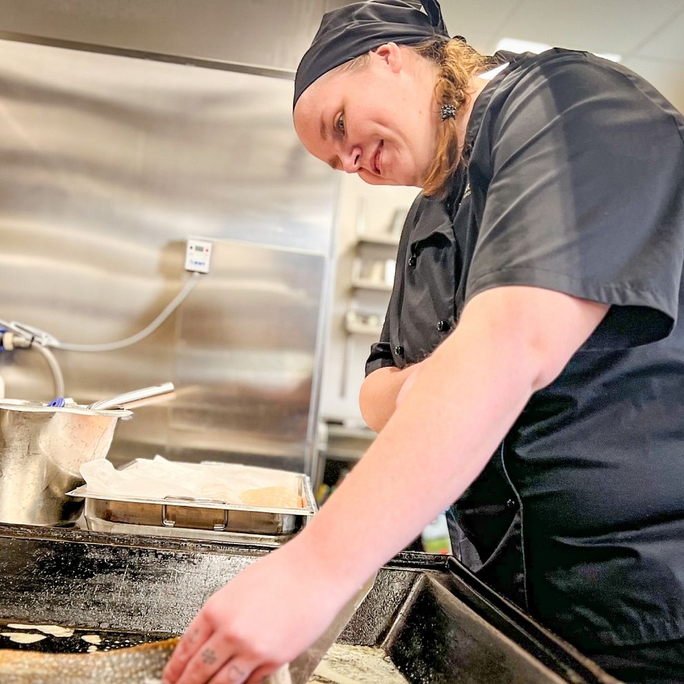 Kock i storkök steker en rödingfilé. kanadaröding från Storsjön serverades äldre i Krokom.