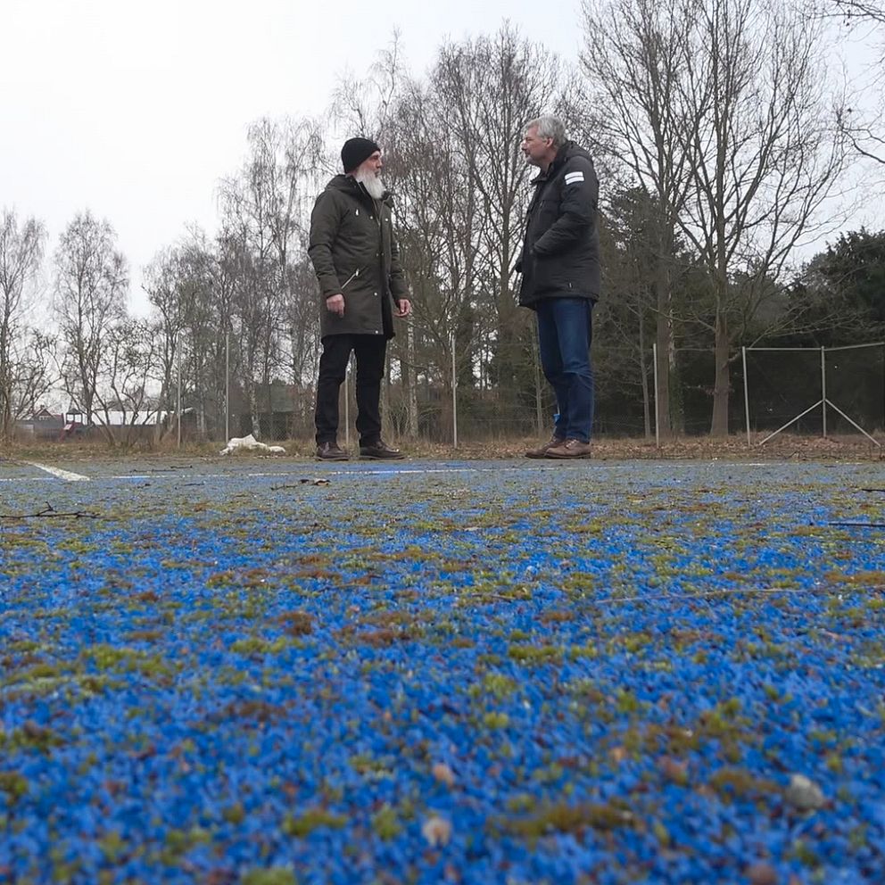 två personer som står på en gammal padelbana