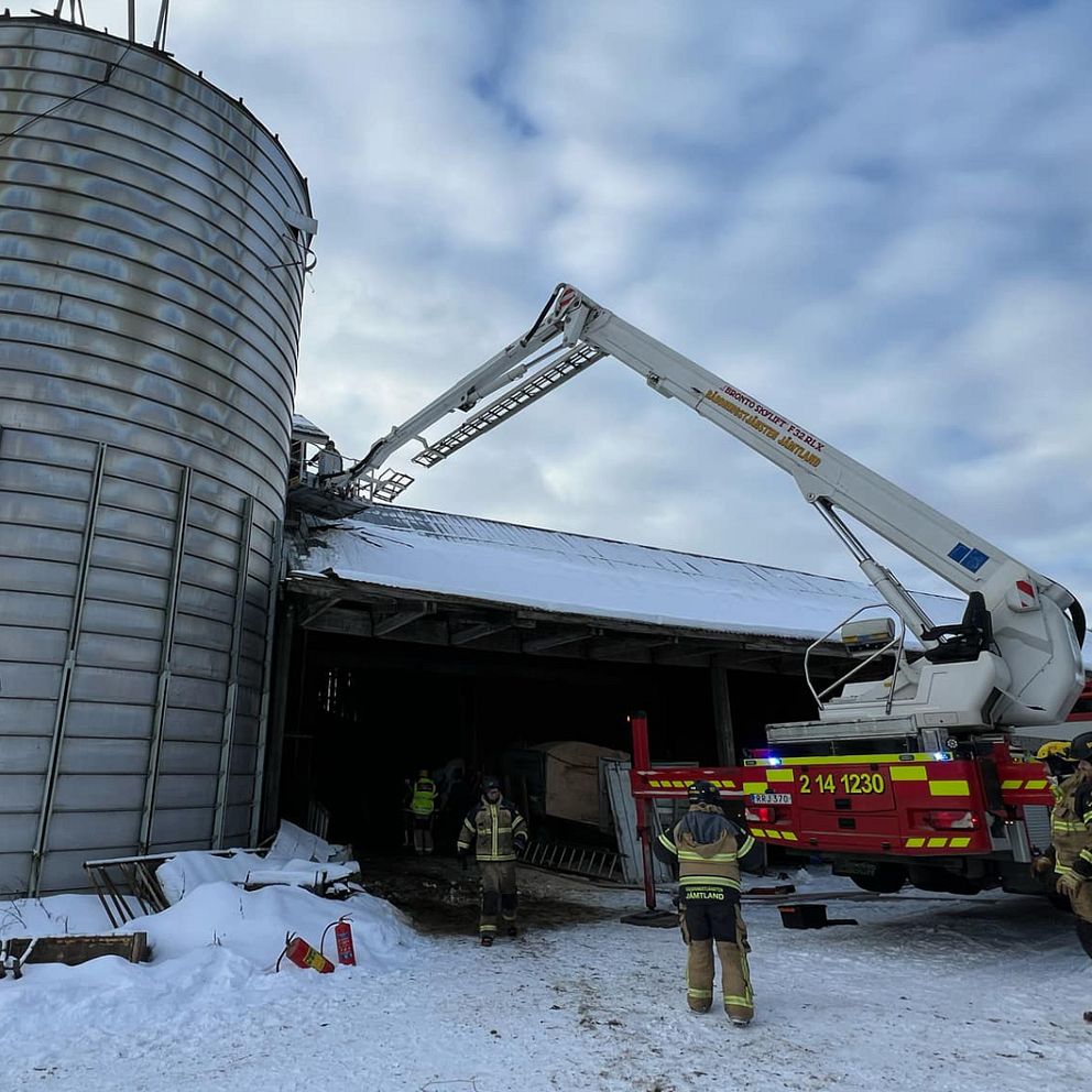 Brandmän och brandbil vid en silo, vintermiljö.