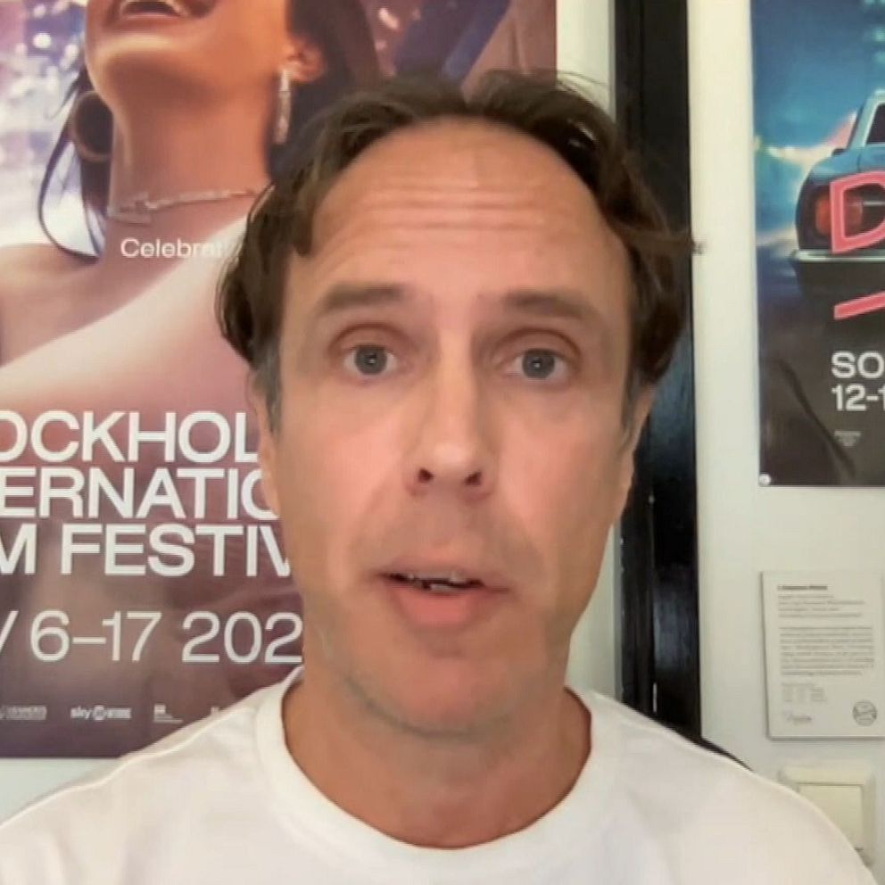En person sitter framför väggar prydda med affischer för Stockholm International Film Festival.