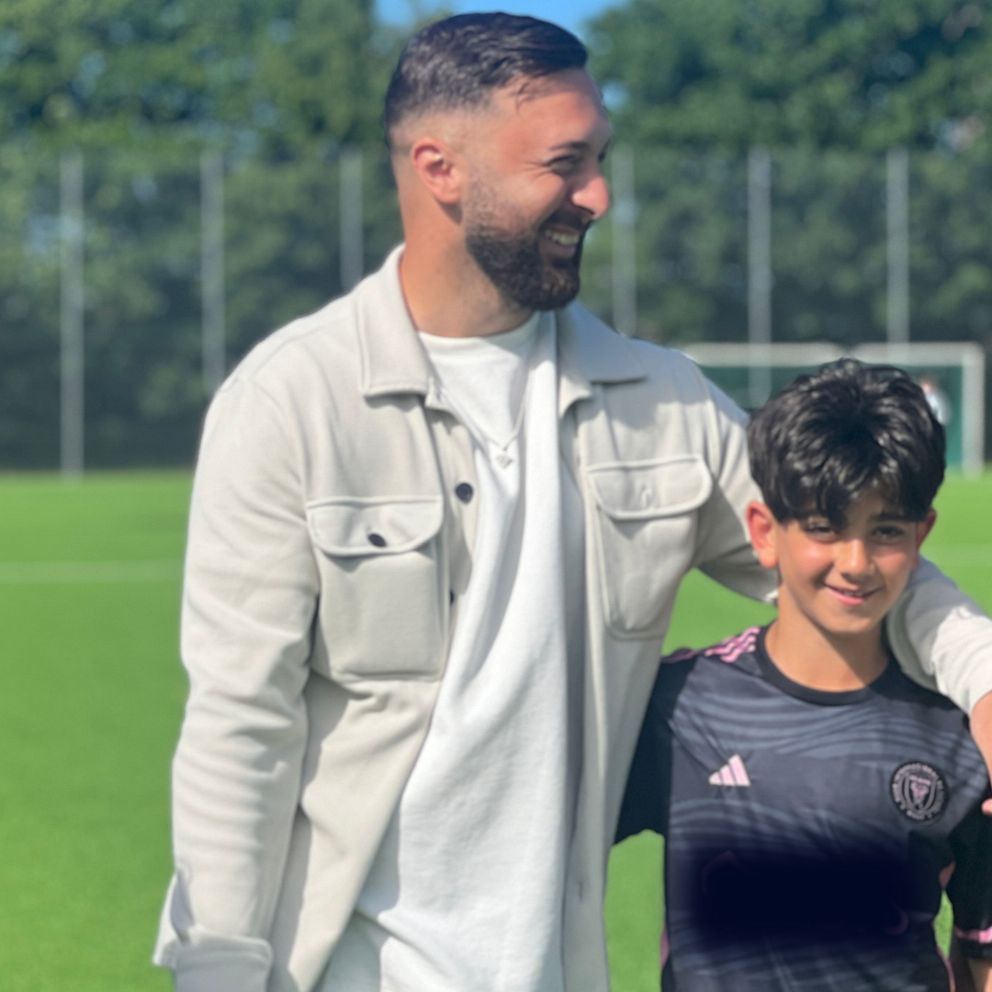 Ordförande för Unite People FC Adnan Bainca med barn på fotbollsplan