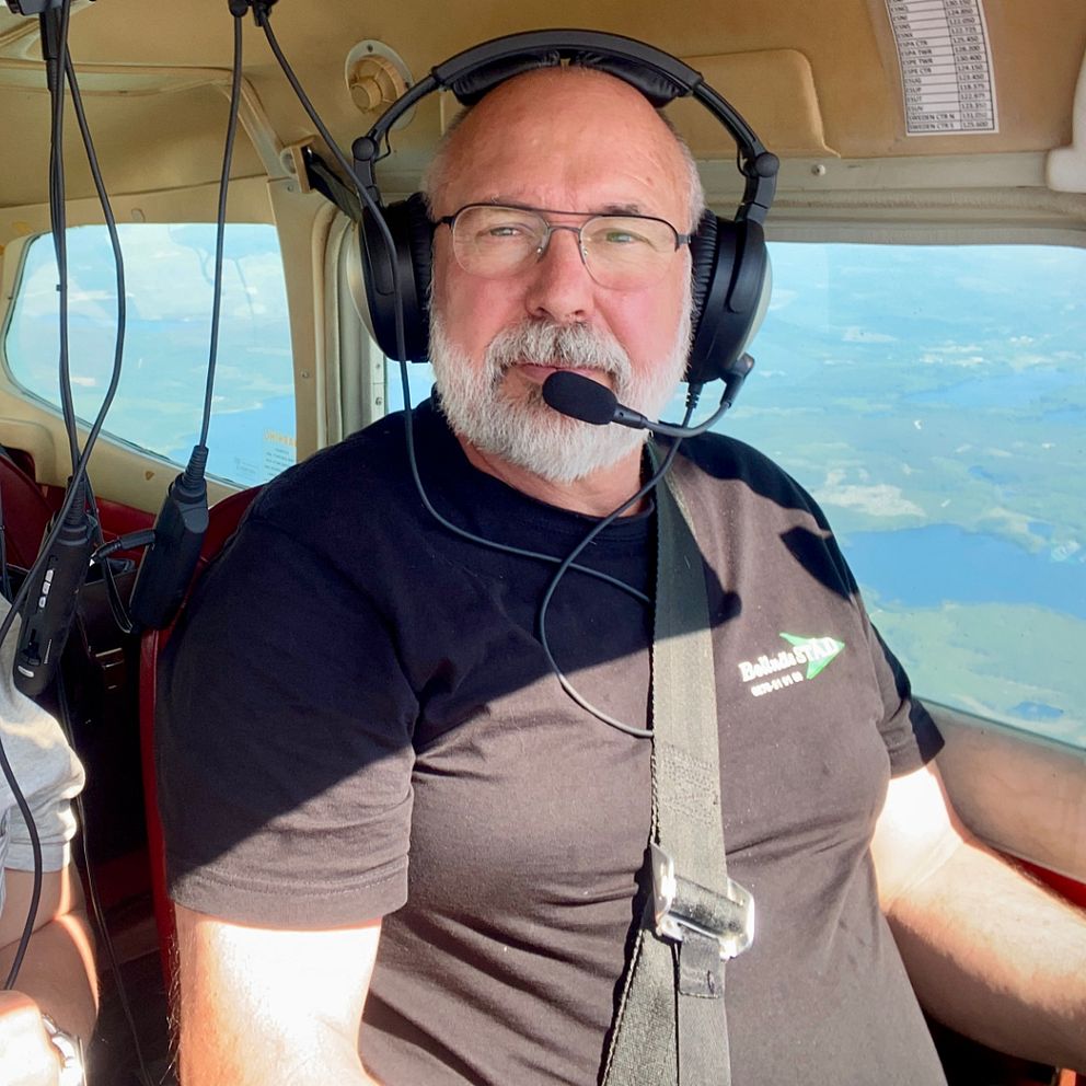 Piloten Mikael Olsson och reportern Lari Honkanen sitter i ett flygplan och spanar efter skogsbränder