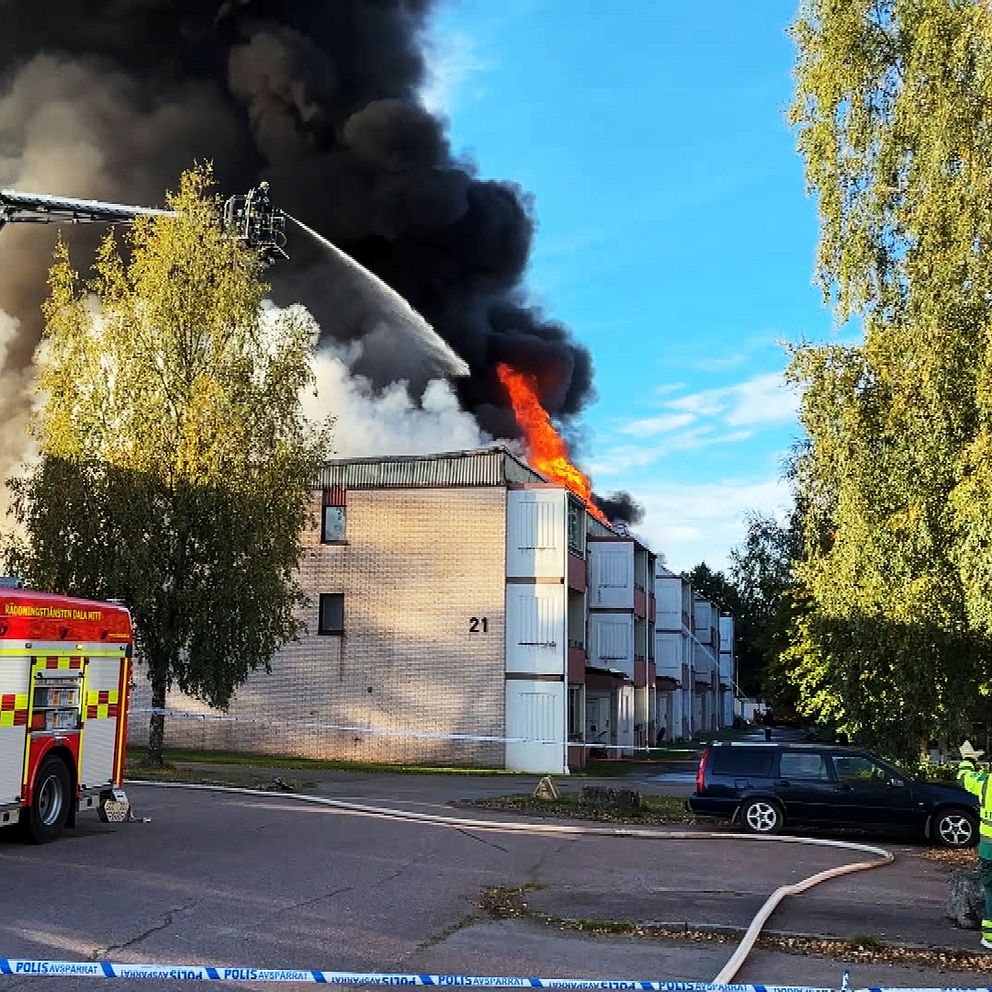 Fire truck and smoke at multi-family house where fire spread from apartment to roof