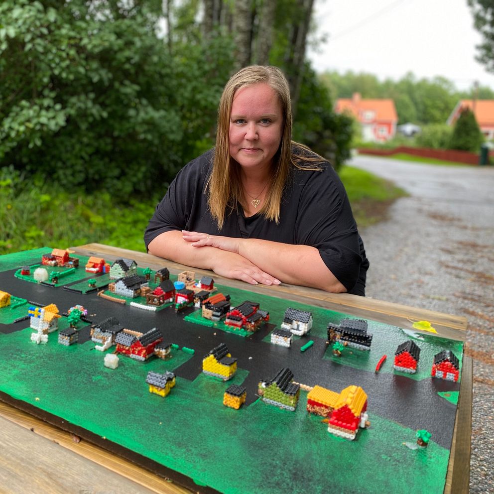 En kvinna bakom en bygator byggd av pärlor
