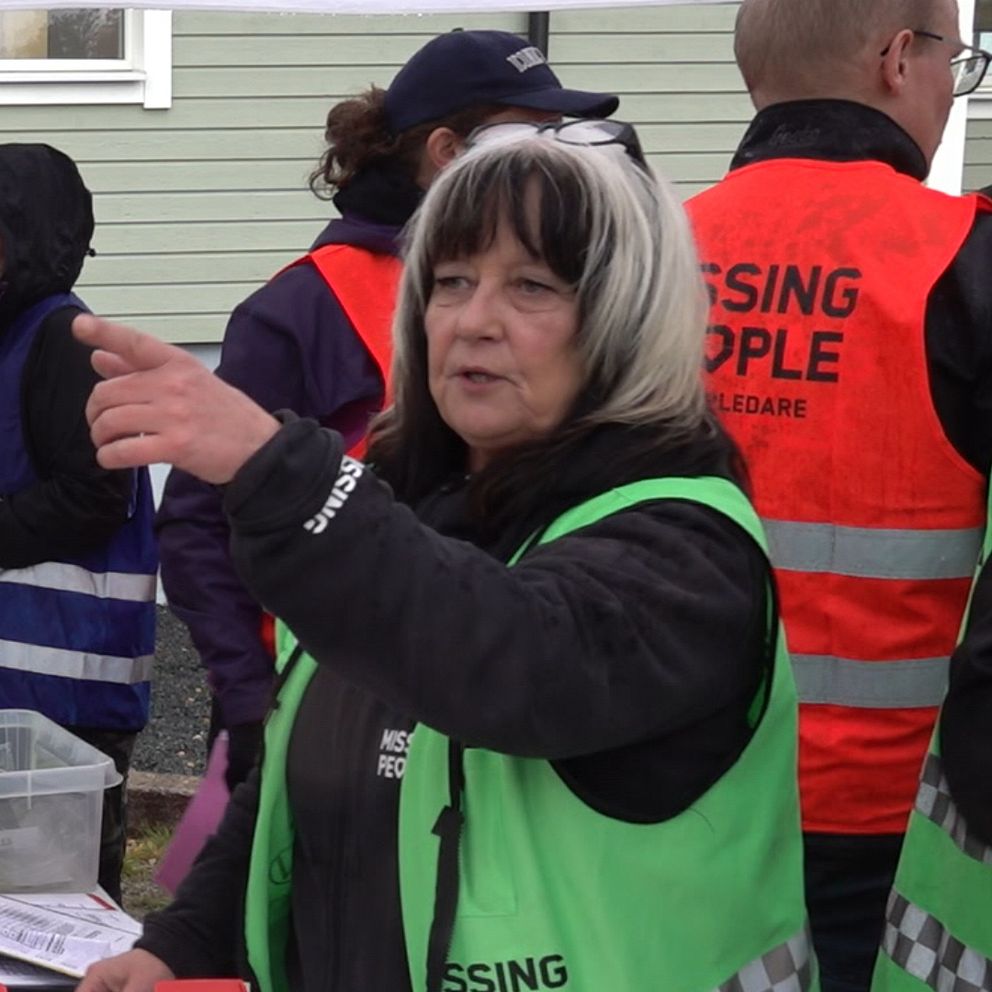 En kvinna med väst med text Missing People.