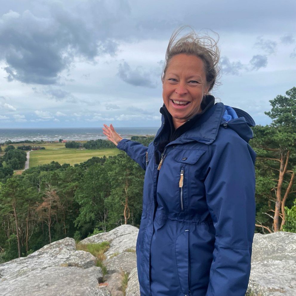 länsstyrelsens reservatförvaltare står uppe på ett berg i Strömkullens naturreservat