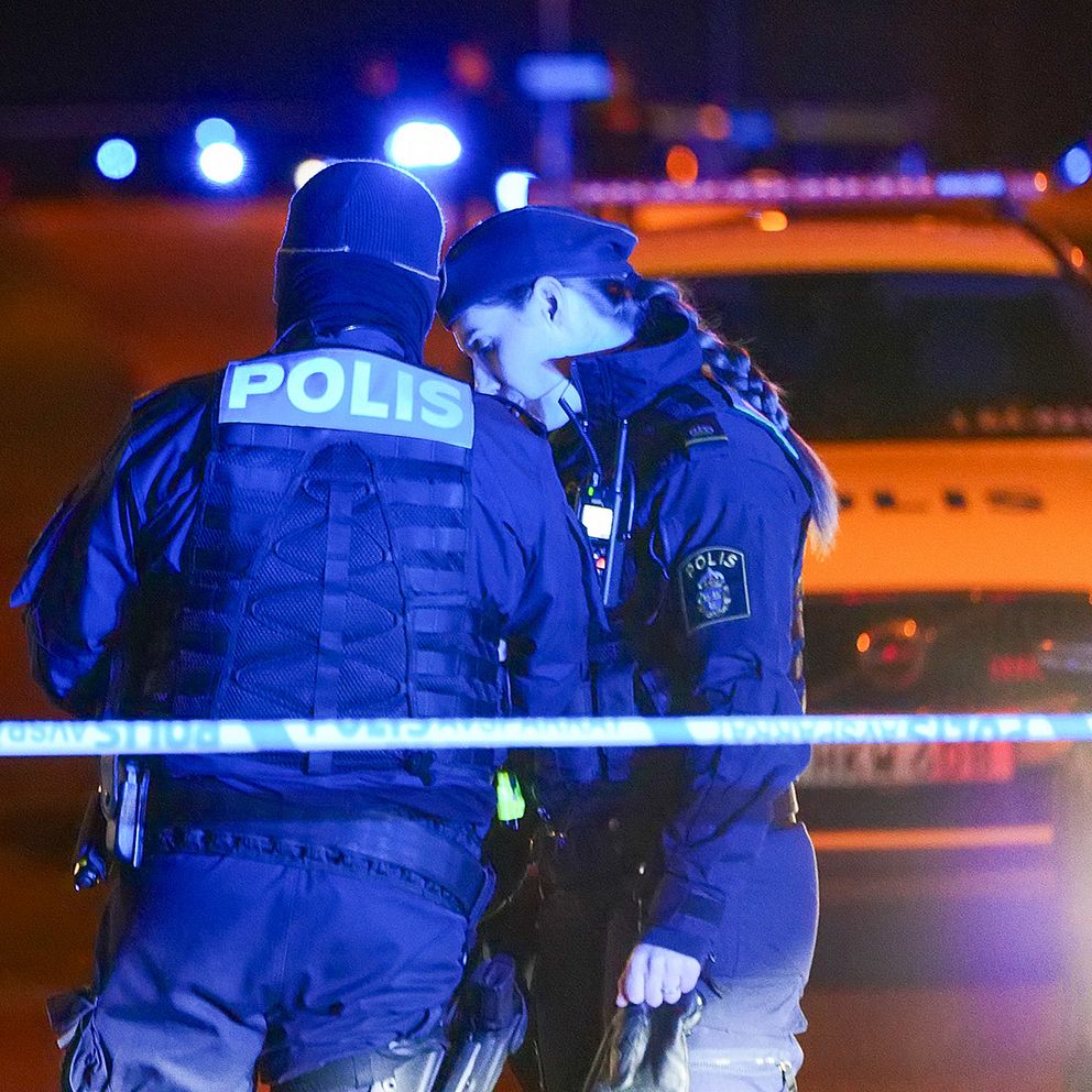 Två poliser vid en avspärrning.