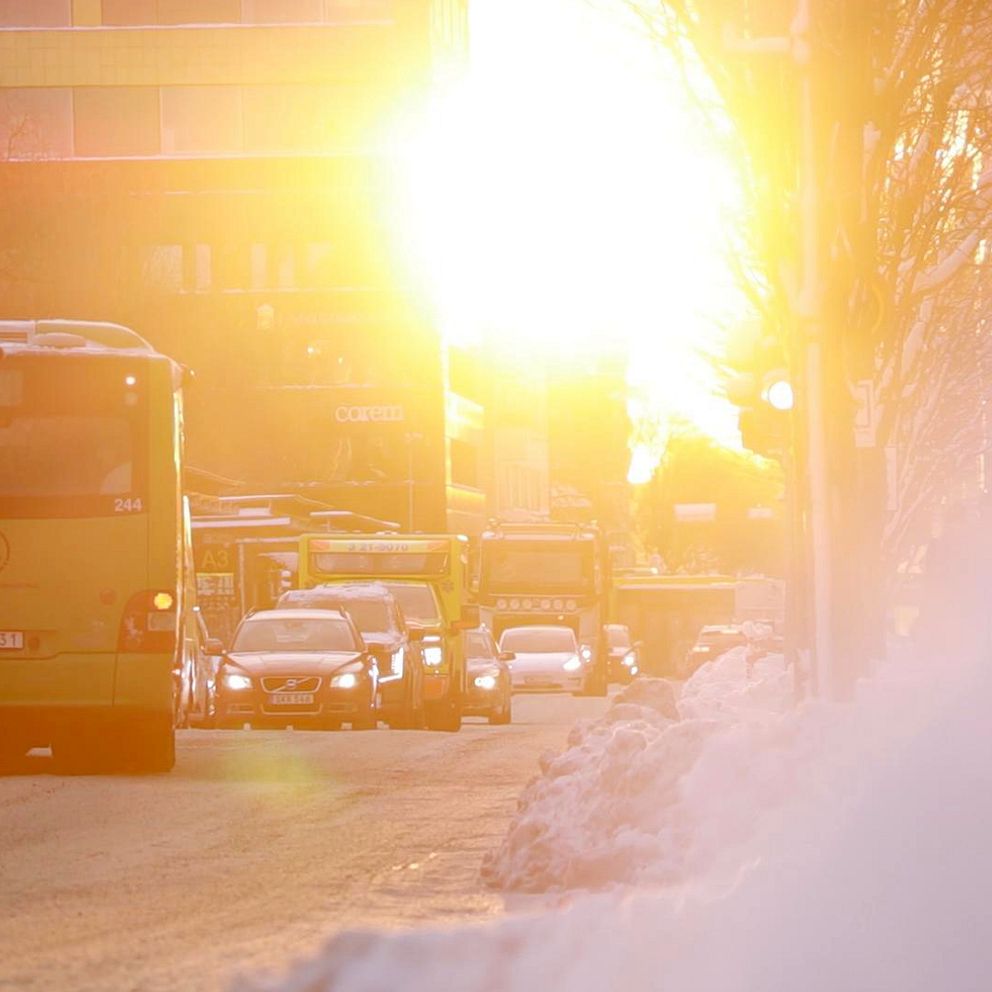 Delad bild: Till vänster, en person med ljusblont hår bär en grå halsduk och en mörk jacka. Till höger, en trafikerad gata med bilar och en buss i solljus, med snö längs vägkanten.