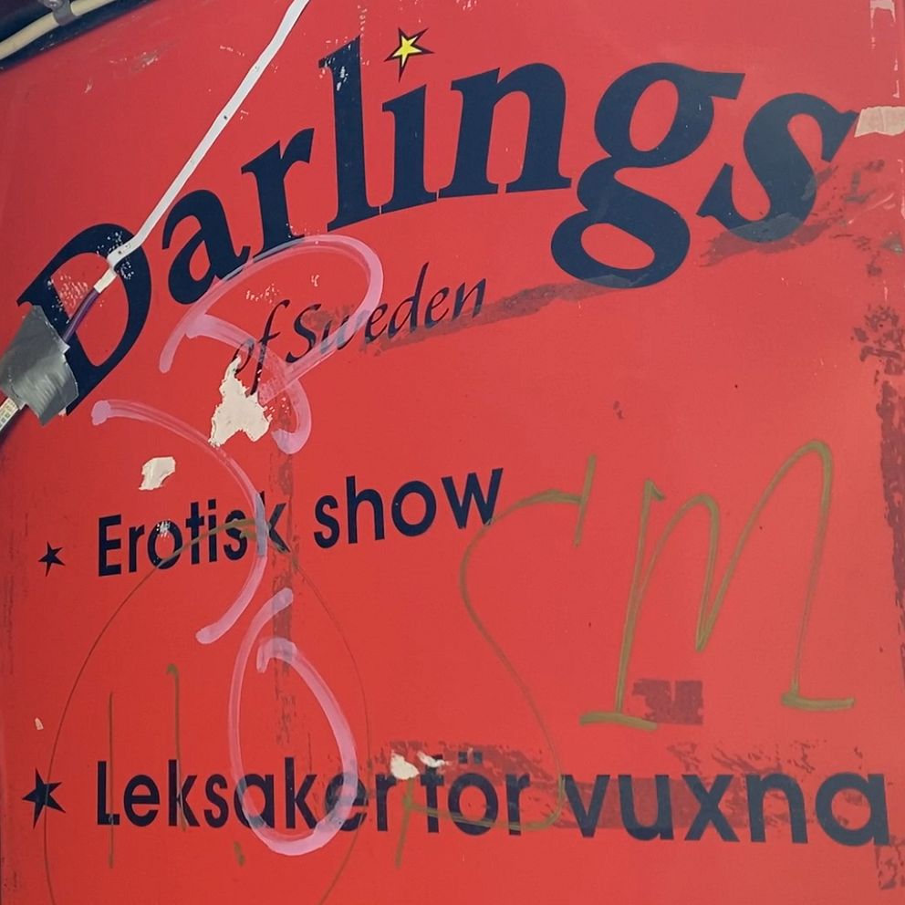 Till vänster står kommunpolisen Henrik Blusi – Till höger ser du en skylt där det står Darlings som är namnet på strippklubben i centrala Sundsvall.