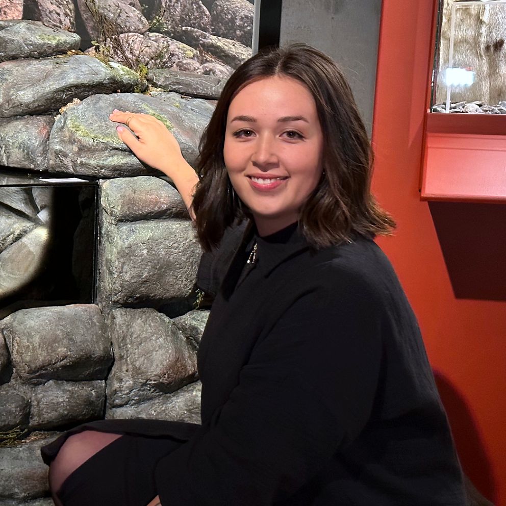 Kulturantikvarie Jana Hader framför bronssmycken som hittats i ett gravröse.