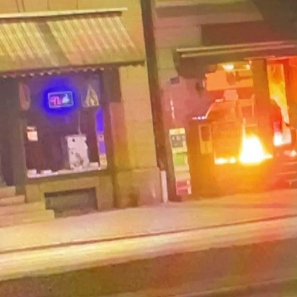 Eld brinner inne i en affärsportal på kvällen.