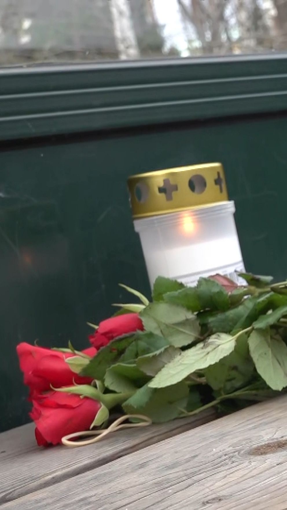 Blommor har lagts på bänken vid den busshållplats där en man i 18-årsåldern igår sköts till döds. Foto: Ann Sehlin/SVT