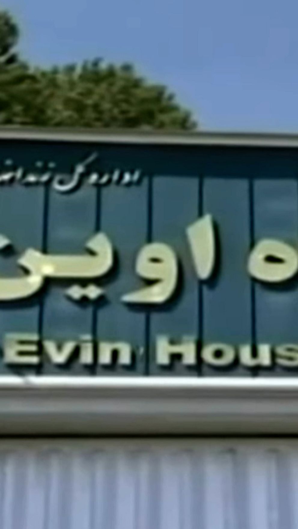 Genrebild från Evinfängelset i Iran. Grön skylt där det går att utläsa ”Evin House of Detention” samt skrift på arabiska.