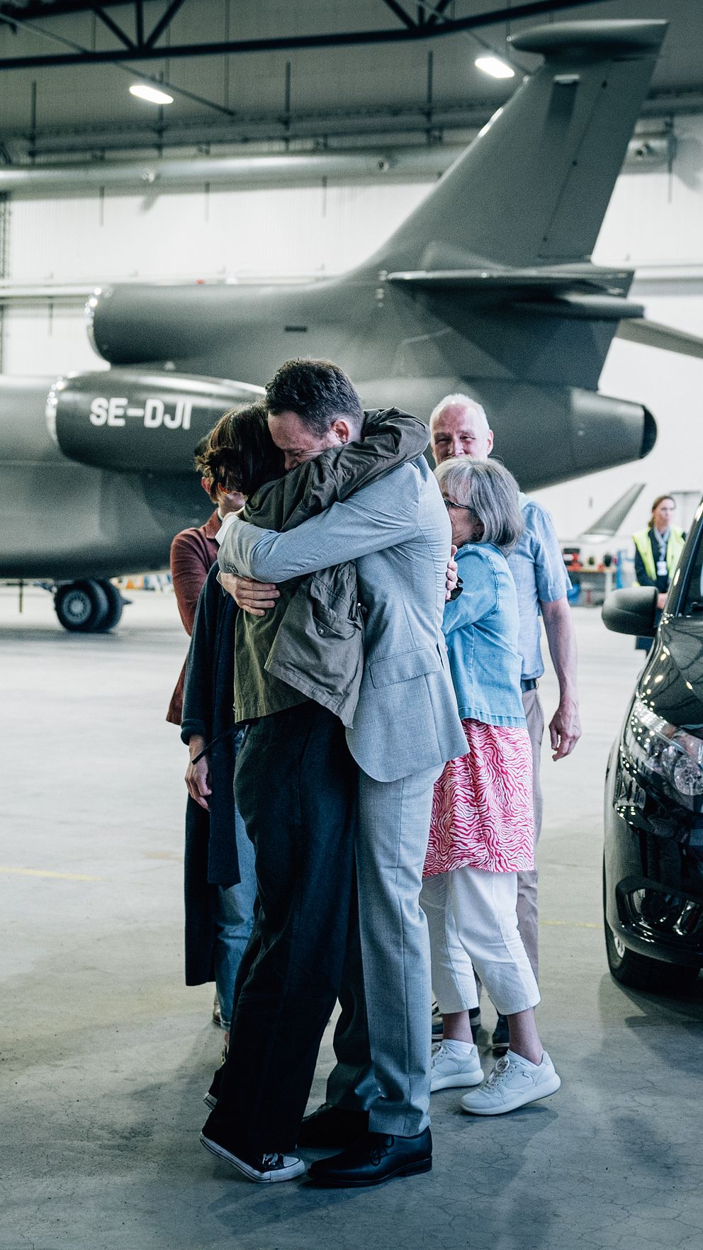 Johan Floderus kramar om sin familj i en flyghangar efter att ha kommit hem från Iran.