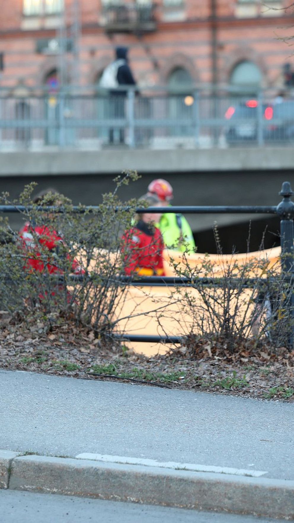 Räddningspersonal arbetar vid vattnet under en bro efter drunkningslarm
