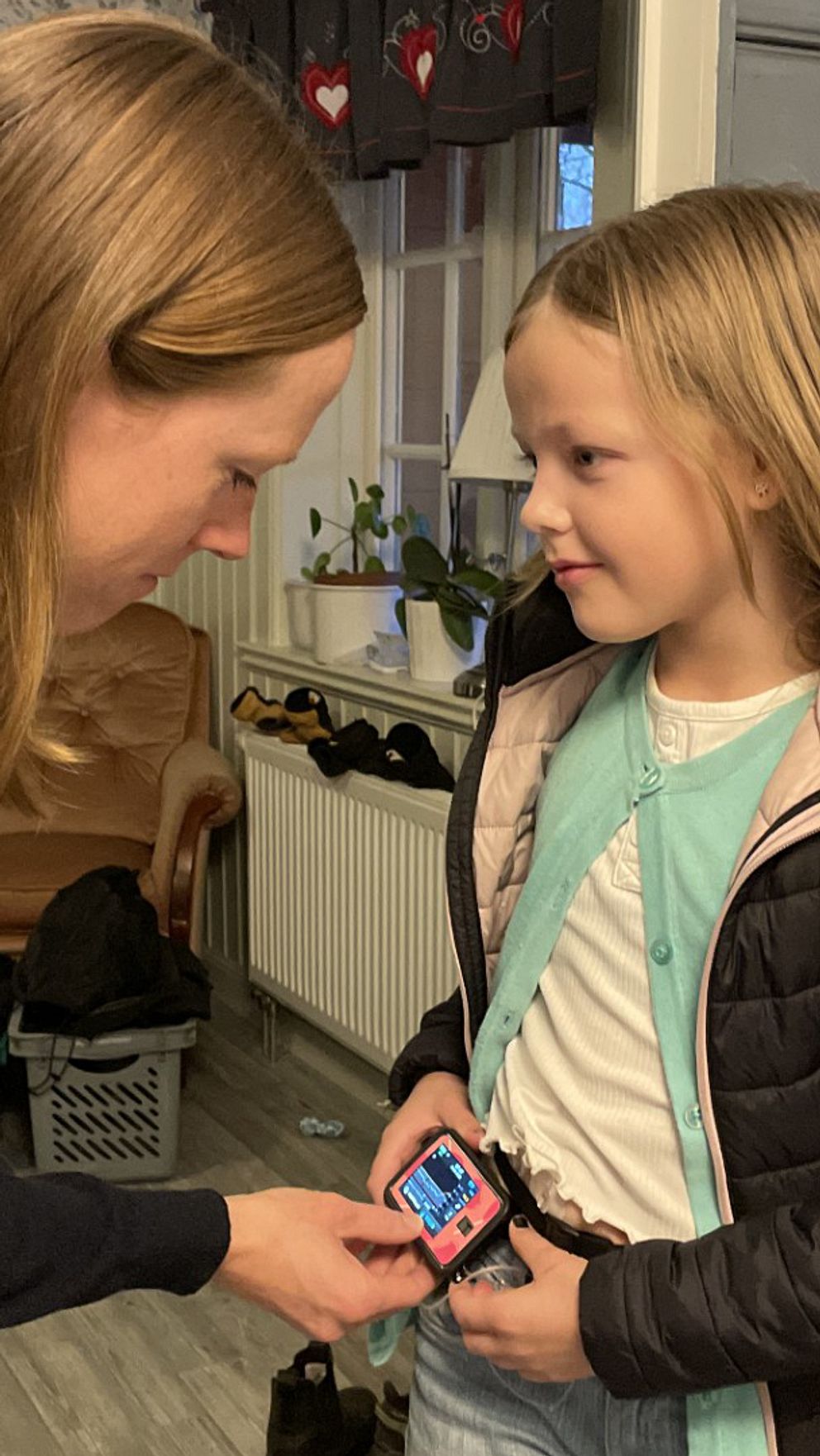 Ida Björk hjälper sin dotter med diabetesutrustning hemma i Hok.