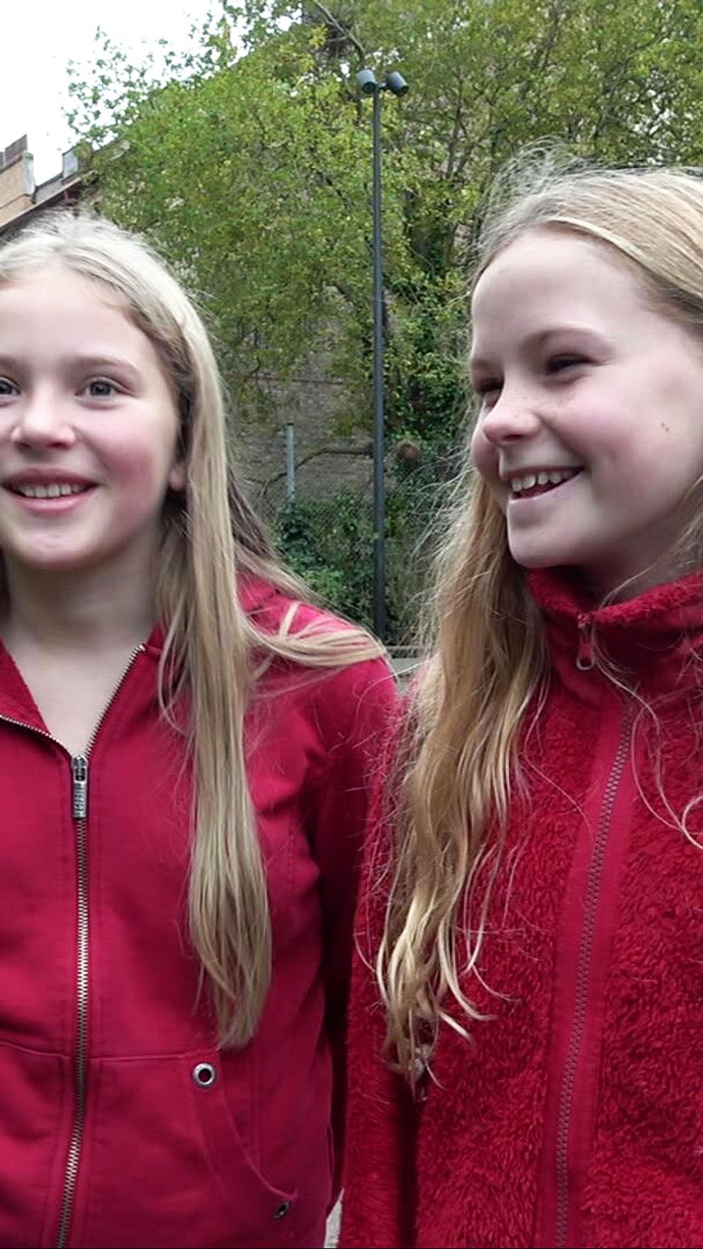 Två femteklassare från S:t Jörgens skola i röda tröjor på skolgården